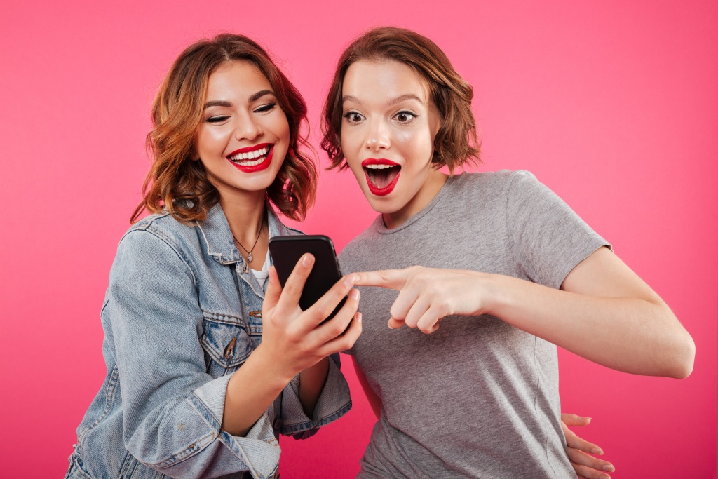 smiling-ladies-friends-using-mobile-phone.jpg
